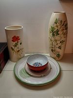 Front view showing both large floral vases, a floral platter, a floral plate, and a floral bowl