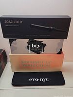 Boxes of José Eber clipless curling iron, BTY Ionic heat brush, Straight Up Perfection styling tool box, and Eva NYC heat mat pouch.