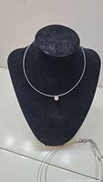 Single round crystal pendant necklace displayed on black bust with thin wire chain, approx. 16 inches