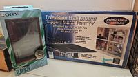 Wide photo showing the Sony cassette recorder box and the PrimeTime TV wall mount box side by side.