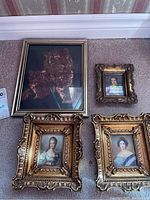 Overview photo of all five framed prints on carpet showing details of the frames and prints.