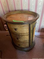 Full view of the oval end table showing the three drawers and overall finish.