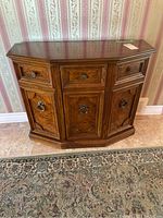 Front view of the hall cabinet showing three drawers on the top and three cabinet doors below, with decorative metal handles.
