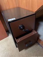 Front and side view of the large safe showing combination dial and drawer partially open.