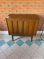 Front view of cabinet showing fluted panel design and tapered legs