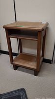 Front view of vintage wood side table showing overall structure and top surface.