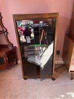 Front view of the vintage wood stereo cabinet with glass doors, showing contents inside and measurement tags.