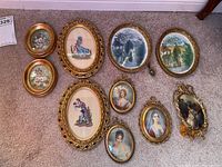 Overview of ten oval framed wall art pieces arranged on carpet.