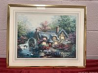 Framed artwork 20x16 inches showing a cottage with a working waterwheel by a river, surrounded by trees and foliage.