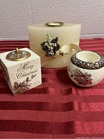 Front view of the three candle holders on a red textured surface