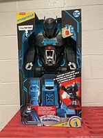 Front view of boxed Bat-Tech Batbot robot playset showing large robot figure in black and blue with bat emblem, and packaging details.