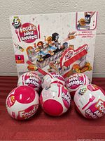 Photo of Foodie Mini Brands Market playset box with 6 sealed Mini Brands surprise balls arranged in front.