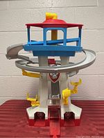 Front view of Paw Patrol tower with spiral grey and yellow slides and yellow periscope