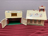 Two vintage Fisher-Price plastic play sets side by side showing doors open and roof details