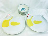 Two chicken-shaped plates and six stacked ceramic bowls with blue floral heart pattern