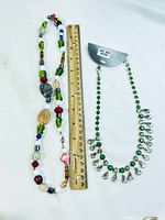 Full view of both necklaces side by side with ruler for scale.