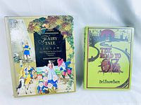 Two books side by side. Left is Fairy Tale Jigsaw book with illustrated fairy tale characters on cover, right is The Road to Oz book with green cover and yellow brick road design.
