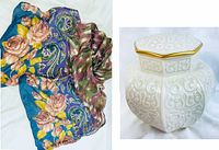 Photo showing the folded silk scarf with colorful floral and paisley patterns alongside the white Lenox ginger jar with gold-trimmed lid and embossed arabesque design.