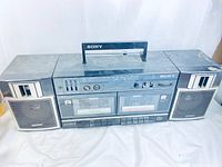 Full frontal view of the Sony boombox showing dual cassette decks, speakers, and carry handle.