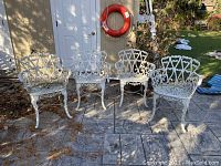 Four chairs arranged on patio stone floor in front of shed door showing entire set