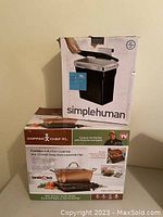 Photo of stacked boxes showing Simplehuman 10L container box on top and Copper Chef XL induction cooktop and casserole pan box below.