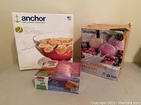 Shows Bimonk Ice Cream Maker Plus box with image of ice cream and fruits, alongside Anchor punch bowl set box and Rubbermaid lunch box set box.