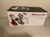 Box front showing KitchenAid branding and image of stand mixers with attachments.