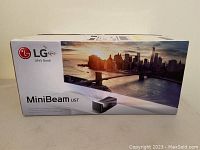 Front view of original LG MiniBeam UST projector box showing cityscape graphic and LG logo