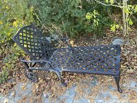 Full side view showing the metal lounge chair with intricate lattice pattern, armrests, and rear wheels.