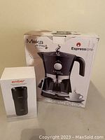 Two boxed items on table: Moka Aroma Espresso machine and Ember temperature control mug.