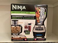 Front view of the Ninja Mega Kitchen System 1500 box showing the XL blender and food processor attachments.