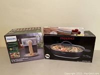 Three boxed items: Philips pasta maker, Paderno skillet, marble rolling pin box