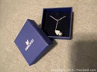 Swarovski blue box with necklace inside showing pendant and chain.
