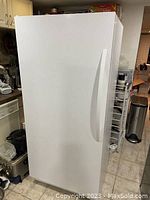 Front exterior of white Whirlpool upright freezer in kitchen