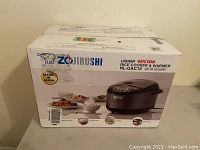 Front of box showing Zojirushi logo, ’Umami Micom Rice Cooker & Warmer NL-GAC18 (up to 10 cups)’ and product image