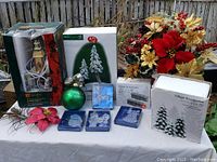 Wide shot of all Christmas decorations included in the lot arranged on a white cloth outdoors.