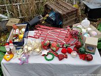 Wide view showing all assorted Christmas decoration items including red sled, fabric Santas, baubles, and small ornaments