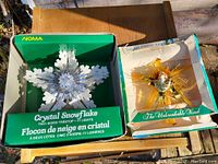 Pair of Christmas tree toppers in original boxes, showing packaging and toppers in situ