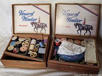 Two open wooden vintage House of Windsor PALMAS cedar cigar boxes filled with assorted sewing supplies including thread spools, needles, pins, and small containers.