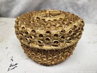 Top and side view of the small round basket showing the intricate curled loops in the split weave pattern.