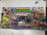 Game box front illustrating Teenage Mutant Ninja Turtles characters and villains in city backdrop, showing full box top