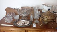 Wide shot of the entire lot showing all glass and ceramic items including punch bowl, pitcher, vases, silver serving dish, and ladle