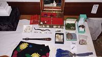 Overview of all jewelry and accessories laid out on a table, showing variety of items including the beaded bag, several watches and bracelets, a jewelry box, and pins.