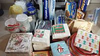 Various Christmas-themed napkins, paper cups, and paper plates along with other paper products.