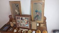 Photo of assorted framed pictures, including two matching bird pictures, a collage, and multiple small frames with prints and portraits.