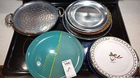 Overview of various sized round serving dishes including glass, metal, and ceramic on stove top.