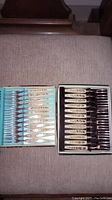 Two sets of small decorative forks in their original boxes