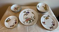 Photo showing full 20-piece set including stacked dinner plates, salad plates, bread plates, soup bowls, and fruit nappies arranged on table.