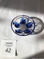 Top view of Lalique cobalt blue ashtray showing flower petal pattern inside and clear edge.