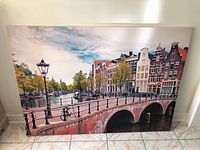 Full view of Amsterdam canal street scene print on stretched canvas, showing bridge, canal, buildings and sky.